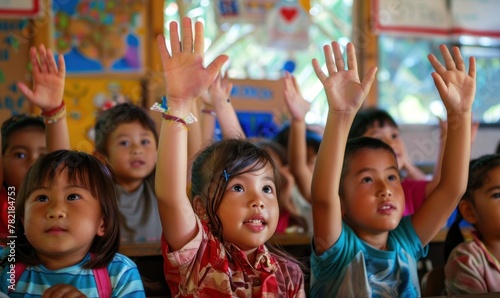 Children at classroom with hands up.