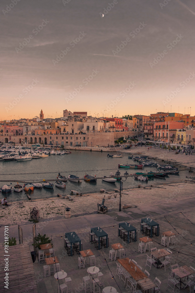 Obraz premium Vista panoramica sul lungomare e porto turistico di Bisceglie in Puglia al tramonto.