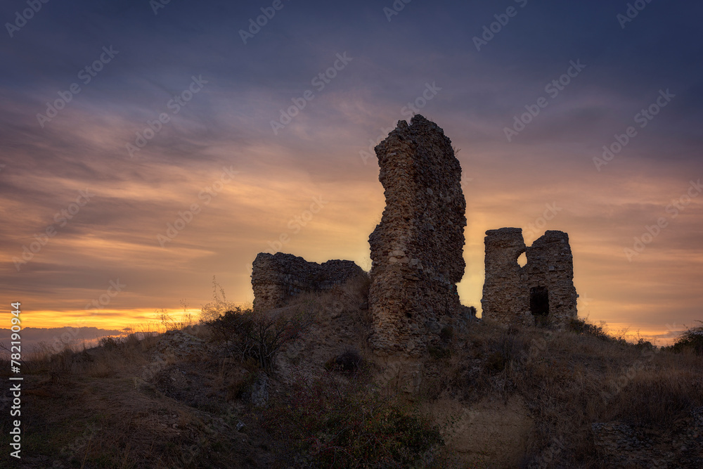 Ruins of the medieval castle of Saldaña in Palencia at sunset with a cloudy sky and warm colors