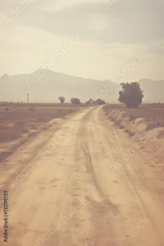 Mystic journey: A serene dirt road leading through a hazy desert landscape