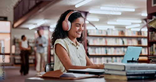 Headphones, dancing or woman in a library on laptop for knowledge, elearning or research in college. Online course, streaming music or happy university student studying information with scholarship photo