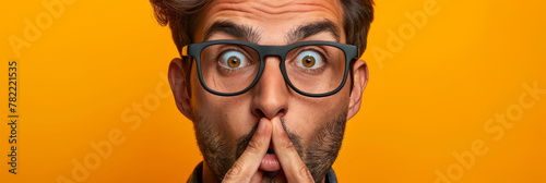 Surprised Young Man with Glasses on Orange Background