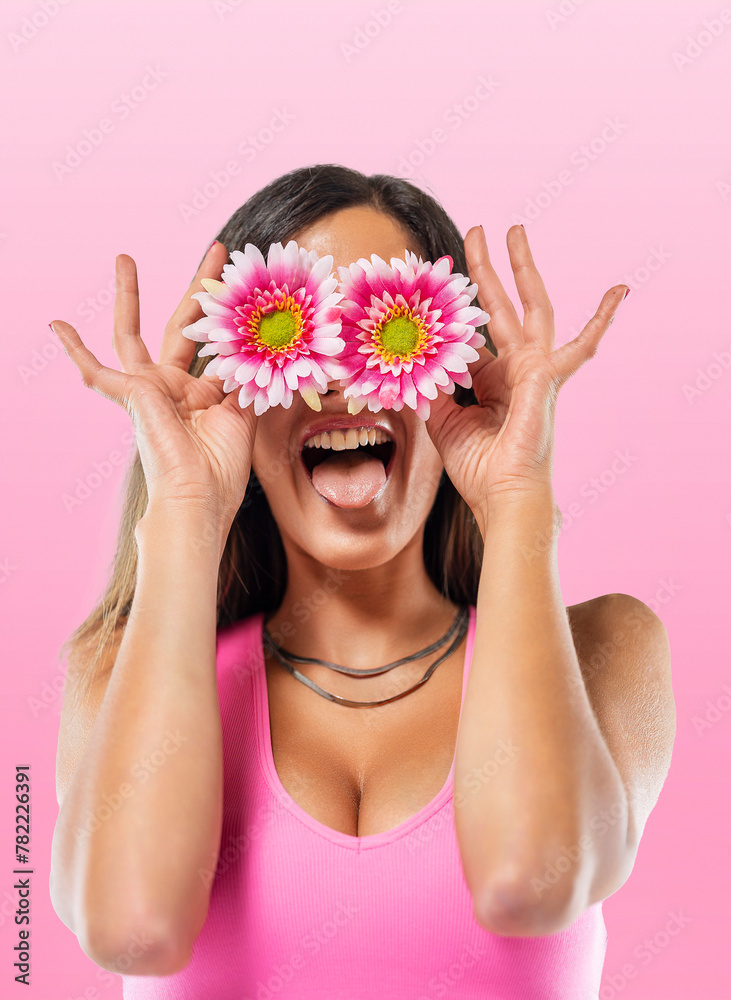 Young woman covering eyes with flowers Young woman covering eyes with flowers