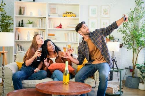 Photography Friends capturing a joyful selfie moment with champagne, sharing laughter in a vibrant, homey living room