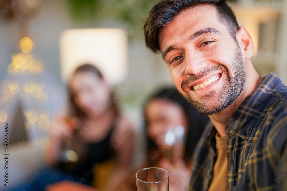 Friends captured mid-laughter as they toast in a stylish home, taking a selfie to remember the cheerful occasion