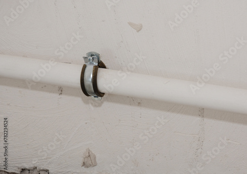 Close up on metal pipe holder in the wall