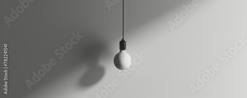 Minimalistic light bulb with shadow on a gray background