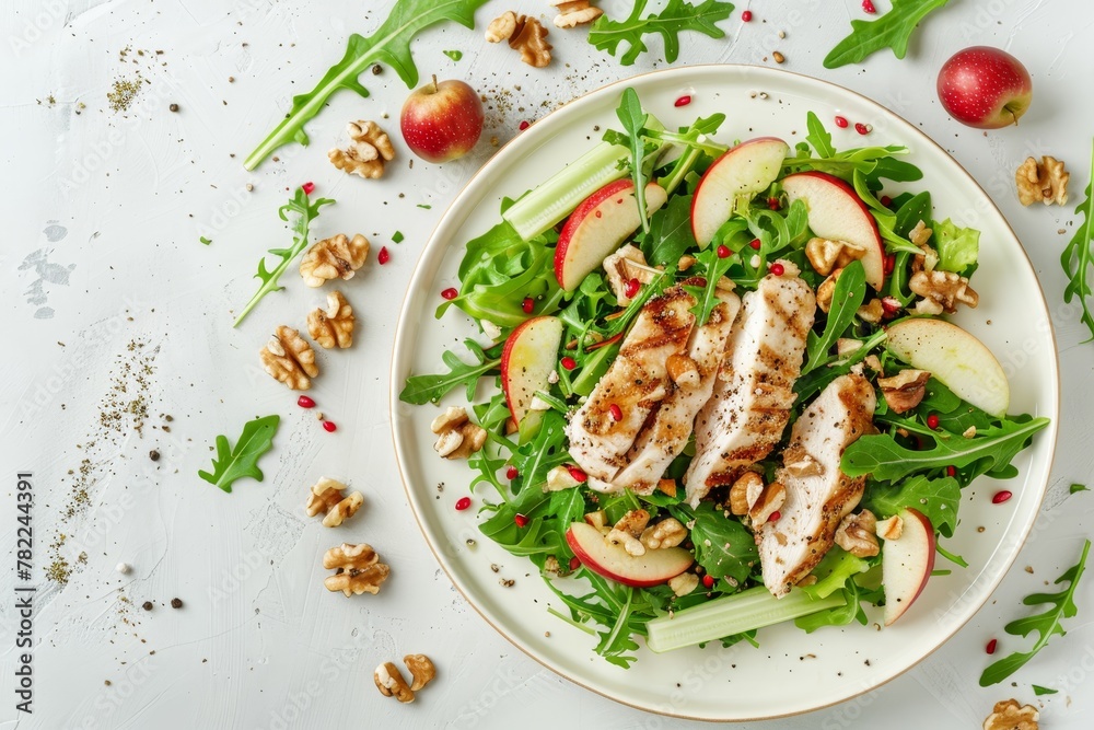 Waldorf salad with chicken apples celery lettuce arugula walnuts on plate white background top view