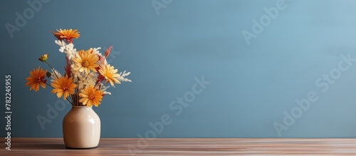 Flowers in vase by blue wall