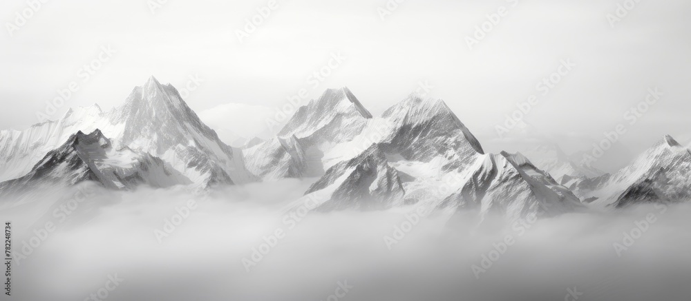 A plane flies alongside misty mountains