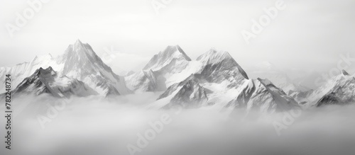 A plane flies alongside misty mountains