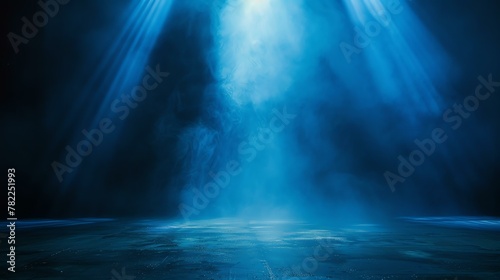 Spotlight on an empty stage. Blue spotlights illuminate the center of the stage. There is a slight haze in the air.