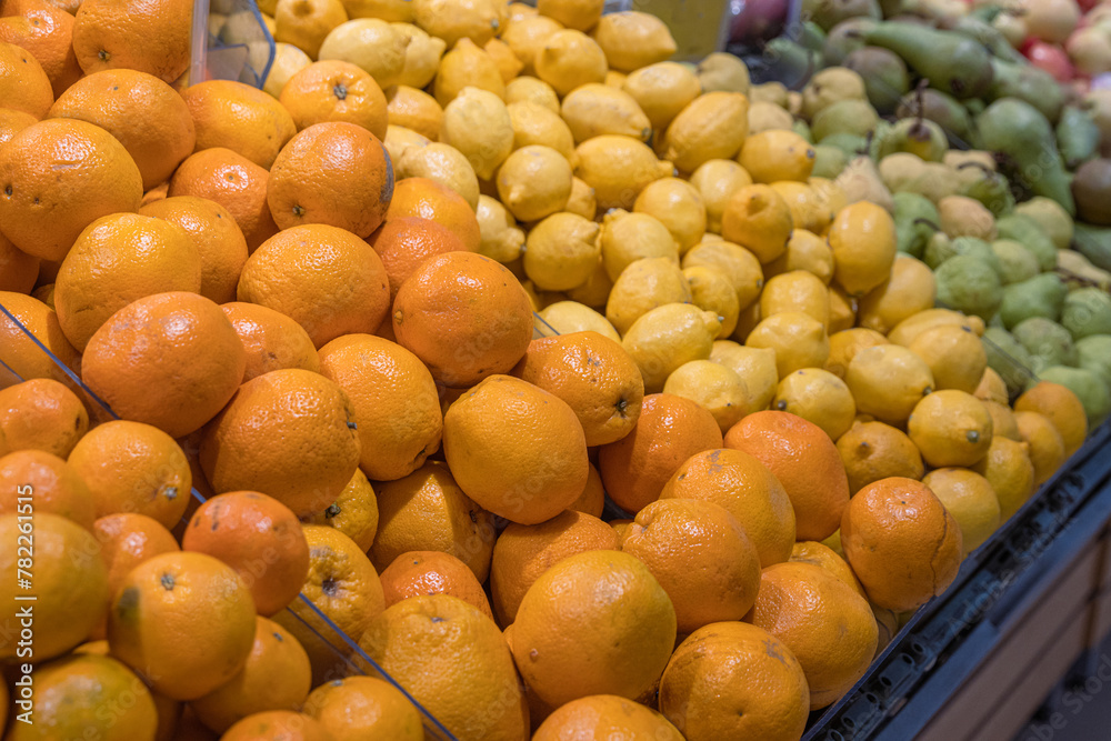 Assortment of fresh fruits arranged in the grocery store on the counter. Oranges, Lemons pears, apples on food market rack. Variety of fruits sold in the store. Side view. Selective focus. 