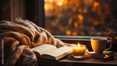 cozy home with candle, book and cup of tea