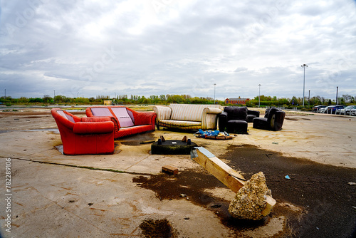Fly tipping household furniture sofas and chairs left illegally by the road side.