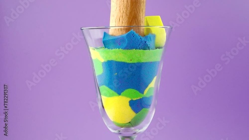 Crush of kinetic sand in a glass on a white background. Very Satisfying and Relaxing Kinetic Sand ASMR video. Cutting anti stress macro close up colorful Kinetic Sand with a Knife. ASMR sounds.