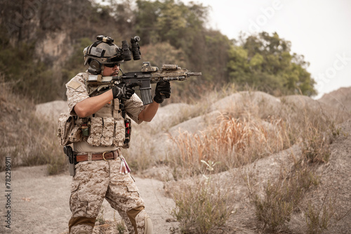 Soldiers in camouflage uniforms aiming with their rifles.ready to fire during military operation in the desert , soldiers training in a military operation