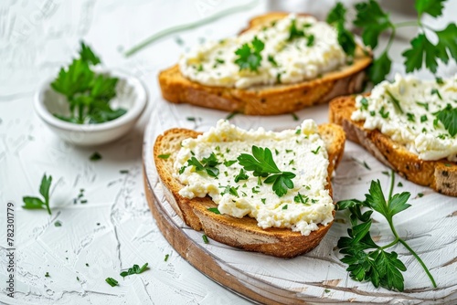 Artisan toast with cream cheese and parsley on wooden board