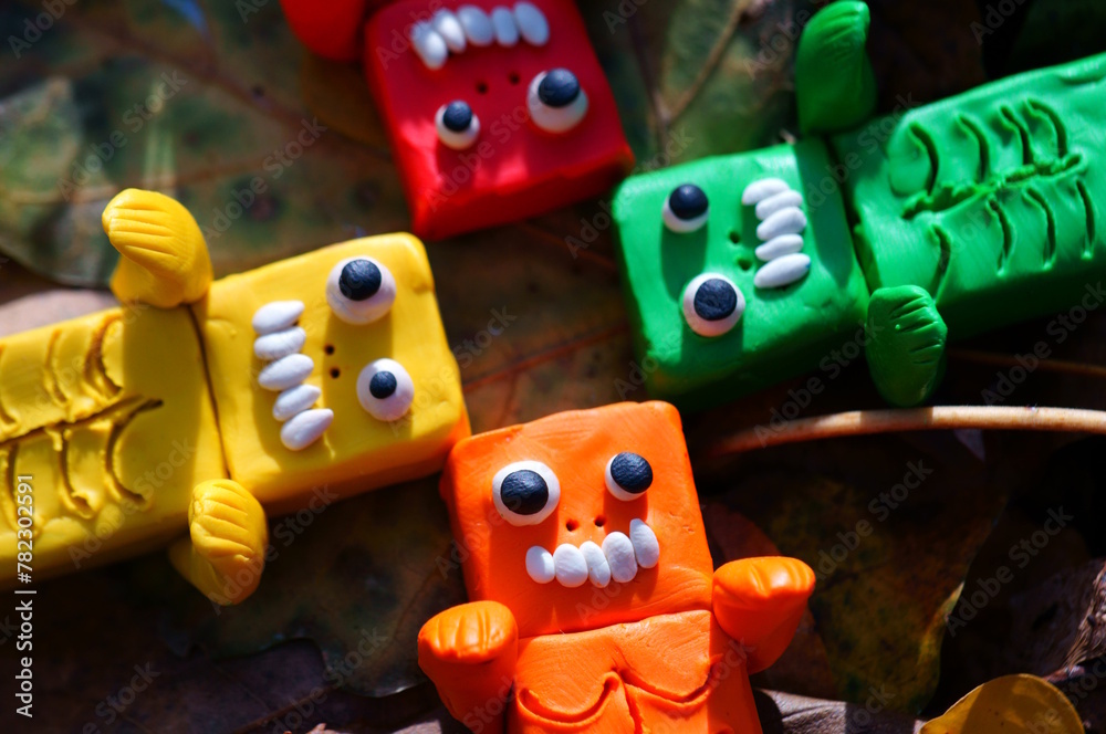 Fototapeta premium Toy monsters lie on autumn leaves. Halloween decorations.