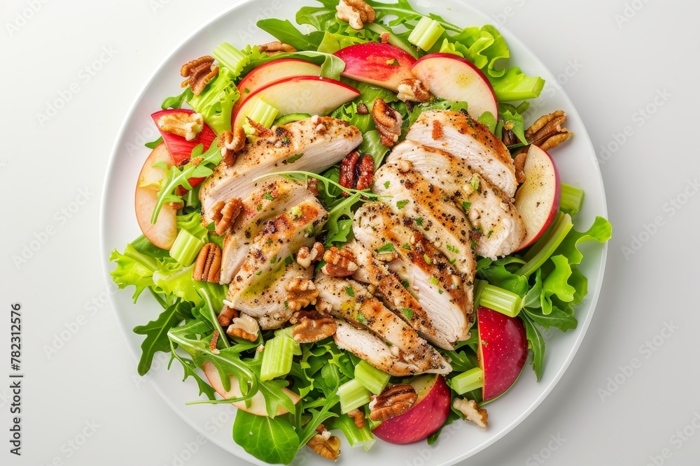 Chicken Waldorf salad with apples celery lettuce arugula and walnuts on white plate top view Chicken Waldorf salad with apples celery lettuce arugula and walnuts on white plate top view