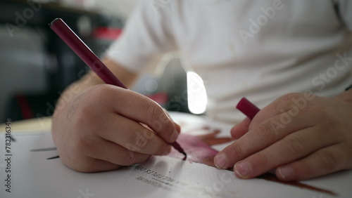 Photos Close-up child hands drawing on paper with coloring pen
