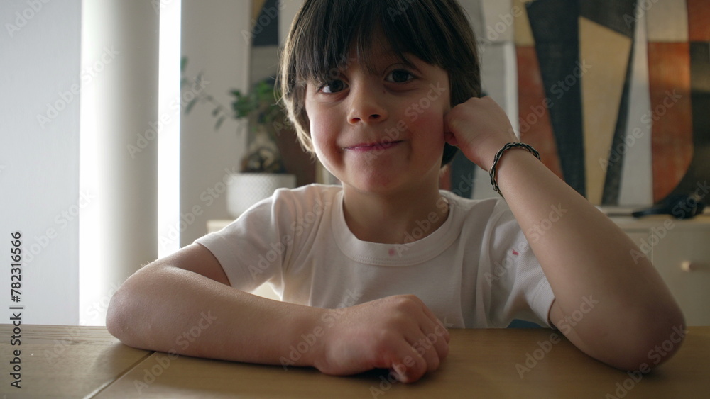 Happy Handsome small boy leaning on table looking at camera smiling. Portrait close-up face of smiling at camera, hands on cheek Happy Handsome small boy leaning on table looking at camera smiling. Portrait close-up face of smiling at camera, hands on cheek
