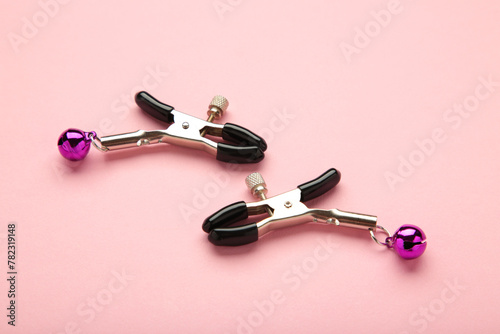 Nipple clamps made of metal with pink bells. BDSM Sex games.