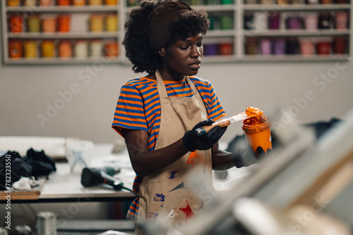 Interracial graphic specialist mixing color and paint at printing shop photo