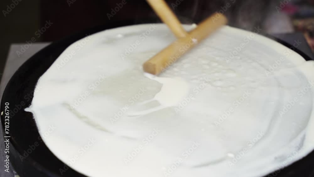 A skilled chef expertly prepares a thin crepe on a hot griddle, flipping it with precision in a bustling Paris cafe. A skilled chef expertly prepares a thin crepe on a hot griddle, flipping it with precision in a bustling Paris cafe.