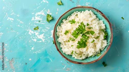 White rice bowl garnished with fresh parsley on a blue background. photo