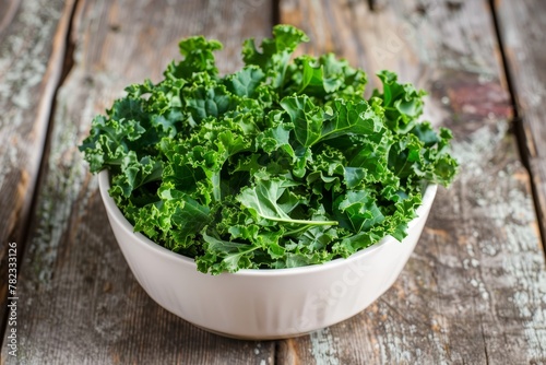 Kale salad served in white bowl on wood table