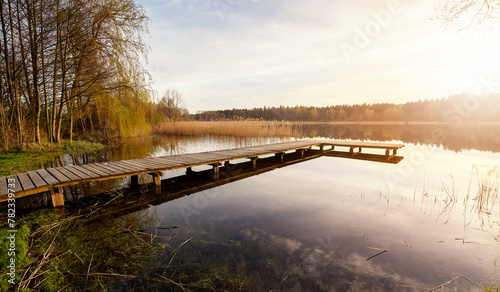 Scenic sunset with a pier on a lake near the town of Recz, West Pomeranian Voivodeship, Poland. © MaciejBledowski