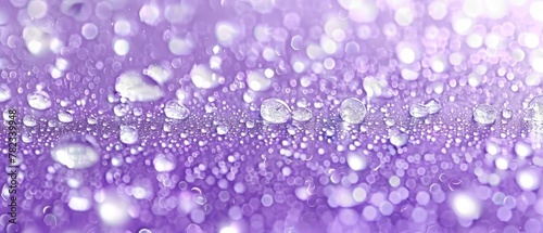  A tight shot of water droplets against a purple backdrop The droplets are softly blurred in an overlay against the solid purple background
