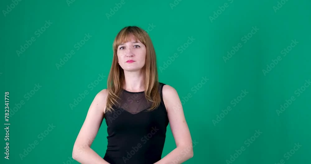 The red-haired girl folds her hands as if praying. Green background The red-haired girl folds her hands as if praying. Green background