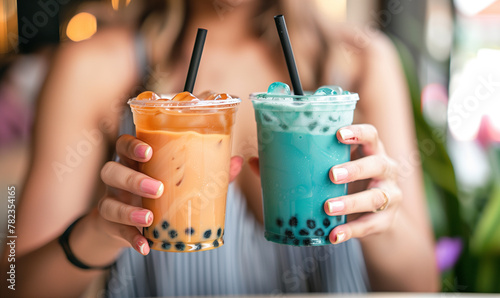 two women hands hold boba milk tea and ceers  photo