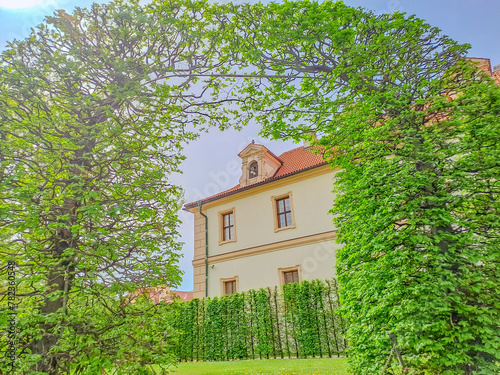 Living green arch of bushes in Wallenstein gardens with baroque palace in Prague photo