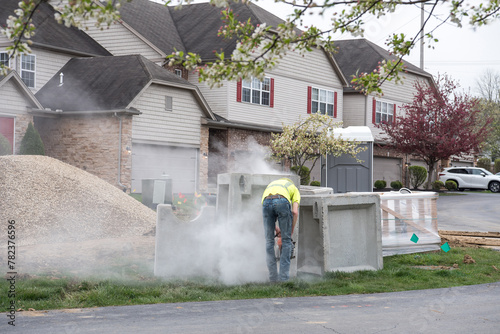 Construction Worker Sawing Cement Block in Cloud of Dust