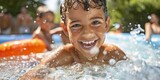 Happy child enjoying summer swim in outdoor pool, multiple people in background, sunny day, water splashes, fun and leisure concept.