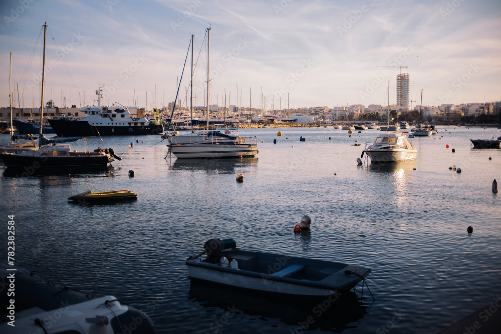 Harbour background. Many sailboats background. Expensive yachts in port. Seashore vacation landscape. Beautiful evening view. Sunrise in sea marina. Water reflection dock. Outdoor ships by the bay.