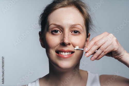 Tableau sur toile Portrait of young woman holding a dental crown, dentistry concept