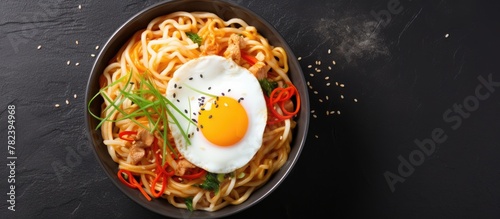 Noodles with egg atop in a ...