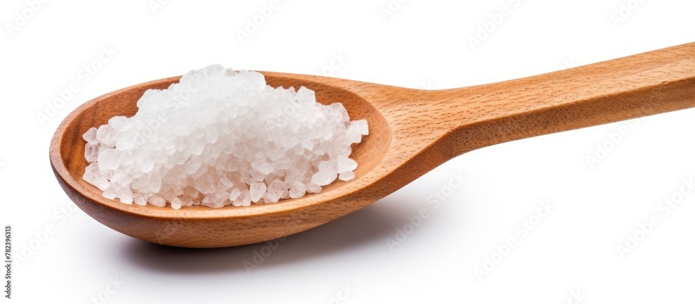 Wooden utensil holding mineral salt on white backdrop Wooden utensil holding mineral salt on white backdrop