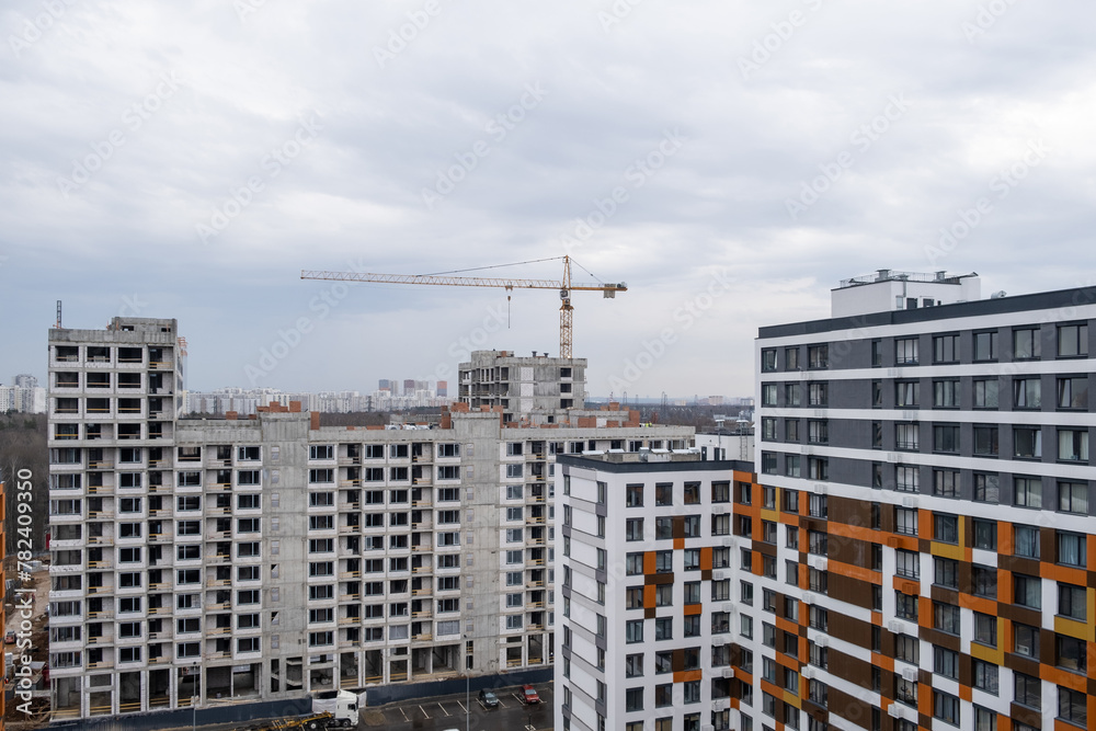 crane and a building under construction against a blue sky background