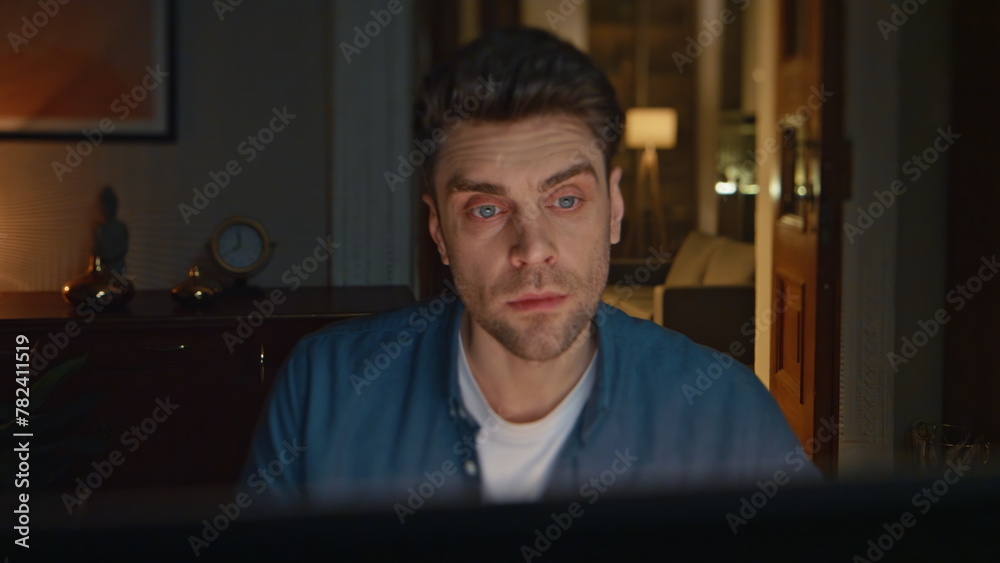 Man workaholic staying late in dark home office closeup. Manager analysing data Man workaholic staying late in dark home office closeup. Manager analysing data