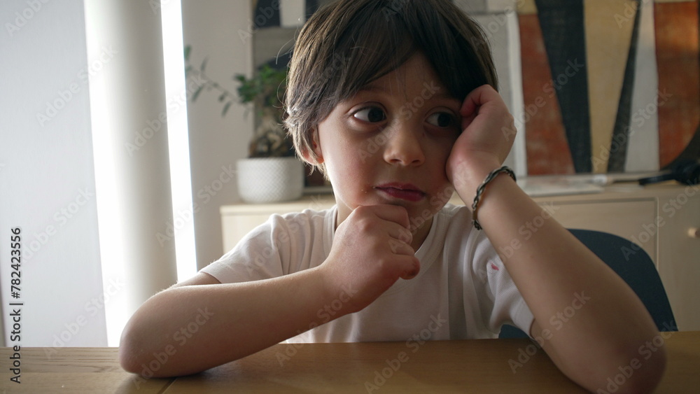Pensive small boy pondering solution to a problem, close-up face of one handsome caucasian 5 year old kif with hand in chin with thoughtful expression Pensive small boy pondering solution to a problem, close-up face of one handsome caucasian 5 year old kif with hand in chin with thoughtful expression
