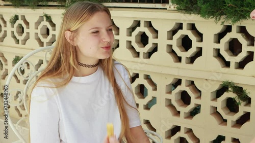 Mom lovingly feeds her teenage daughter delicious churos in the fresh air, enjoying warm day and pleasant conversation. Traditional Spanish pastry churos