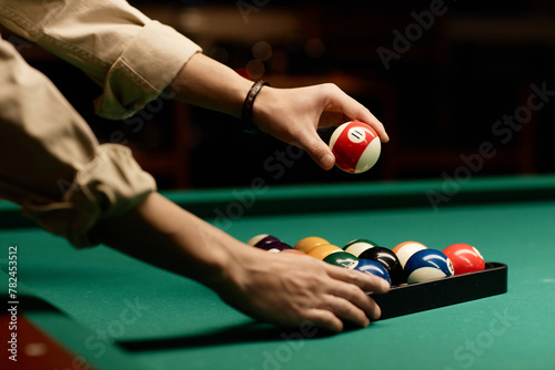Minimal side view closeup of male hands setting up billiard balls on pool table copy space