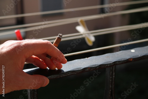 Foto Smoking cigar on balcony man hand close up
