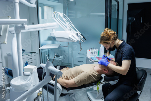 Modern stomatological office. An orthodontist installs braces. Treatment of teeth of a person with an incorrect bite. Treatment of teeth photo