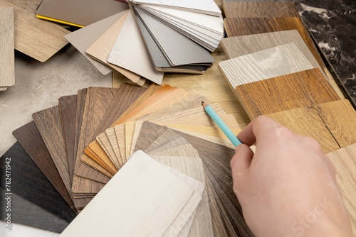 A woman designer shows with a pencil that she is holding in her hand, what is the best choice for the design of your project. The concept of design and selection of materials for the manufacture of